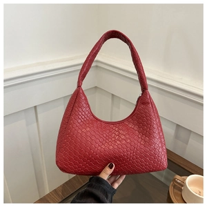 Vue détaillée d'un sac hobo rouge tressé avec une poignée intégrée sans couture