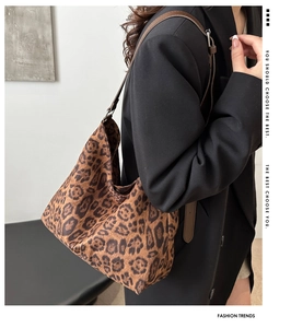 Detail of adjustable leather strap and leopard print canvas on large hobo bag
