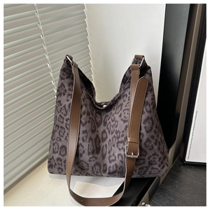 Close-up of leopard print canvas tote bag with adjustable brown leather shoulder strap