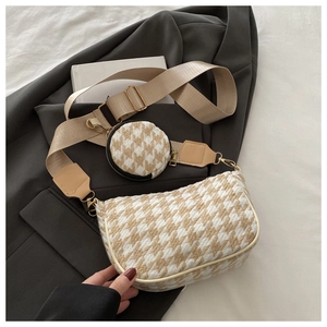 Detail of houndstooth crossbody bag with matching round coin purse and wide canvas strap