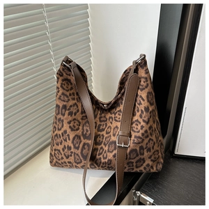 Detail of leopard print tote bag with brown leather strap and silver hardware buckle