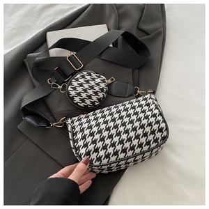 Detail of houndstooth crossbody bag with wide strap and removable small round pouch