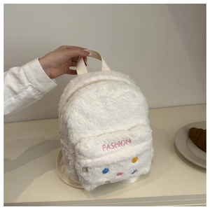 Detail of white plush backpack with pink FASHION embroidery and colorful polka dots