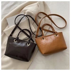 Detail of premium PU leather tote bags in dark coffee and caramel with fashion embossing