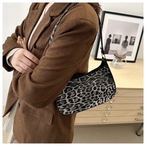 Detail of leopard print shoulder bag featuring adjustable gold buckle and leather strap