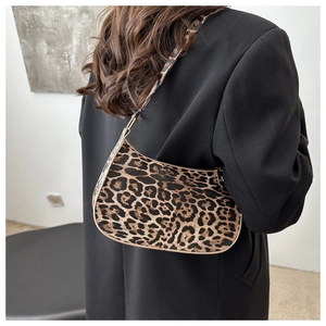 Detailed view of leopard print hobo bag worn with a black blazer for a stylish look