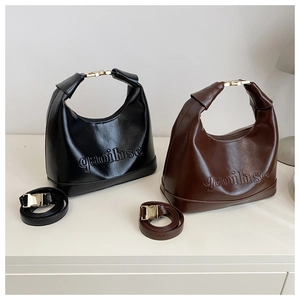 Detail of minimalist hobo bags in black and brown featuring embossed letter texture