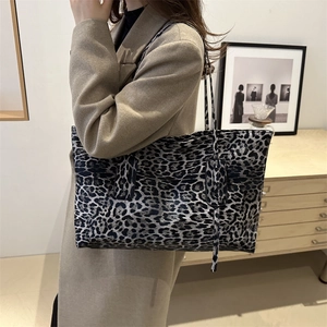 Grand sac cabas léopard gris foncé porté avec un manteau d'automne de style chic
