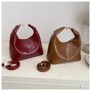 Detail of vintage hobo bags with embossed lettering and gold metal buckles