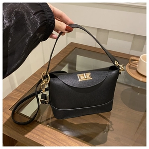 Close-up of black lychee grain leather bag with elegant gold twist lock and handle