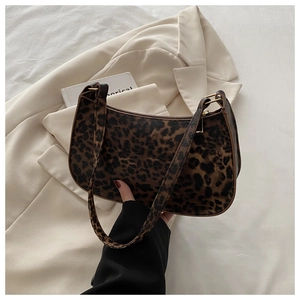 Detail of leopard print underarm bag with gold metal buckle on a beige blazer