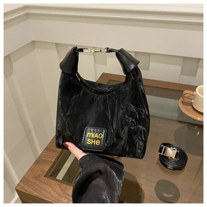 Detail of black pleated texture shoulder bag with MIAO SHE leather patch and metal buckle