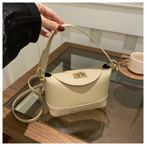 Detail of off-white lychee leather handbag with golden twist-lock and adjustable strap
