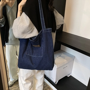 Large dark blue denim tote bag with contrast stitching and leather patch for daily use