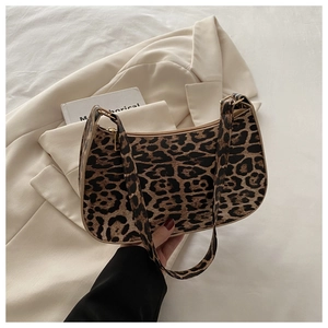 Close-up of leopard print hobo bag with gold zipper detail on beige blazer background
