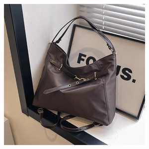Detail of coffee nylon tote bag with decorative buckle and smooth metallic hardware
