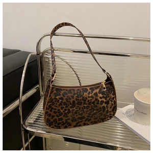 Detailed close-up of leopard print baguette bag with golden metal zipper and hardware