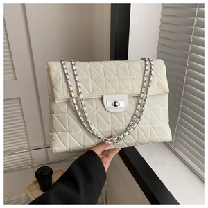 Close-up of beige quilted crossbody bag with silver twist-lock and chain strap detail