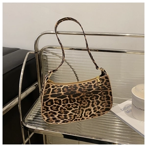 Detailed view of leopard print baguette bag featuring a gold metal zipper and PU texture