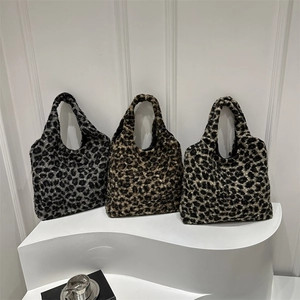 Trois grands sacs cabas en peluche à imprimé léopard en gris et marron sur socle