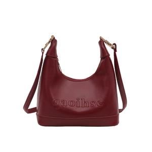 Minimalist red leather half-moon shoulder bag with embossed letters and gold metal hardware