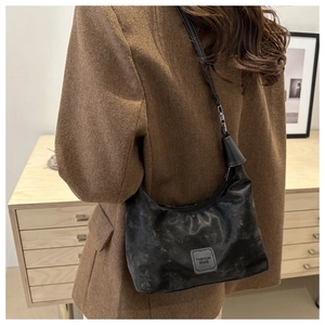 Detail of black hobo bag with textured leather and Fashion Bags logo on a model