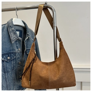 Dettaglio borsa Hobo marrone in pelle opaca con tracolla larga e nappine lunghe