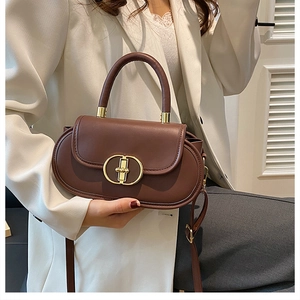 Dettaglio borsa a mano marrone in pelle vintage con chiusura dorata e manico corto