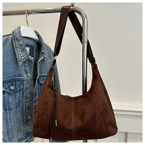 Dettaglio borsa hobo in pelle scamosciata marrone con cuciture bianche e tracolla larga