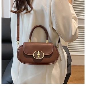 Dettaglio della borsa a tracolla vintage in pelle marrone scuro con fibbia dorata