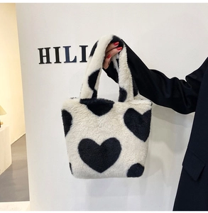 Dettaglio della borsa tote in ecopelliccia bianca con motivi a cuore nero e consistenza soffice