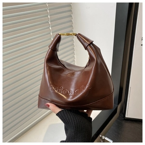 Close-up of dark brown hobo bag featuring mioashe embossed text and gold metal buckle