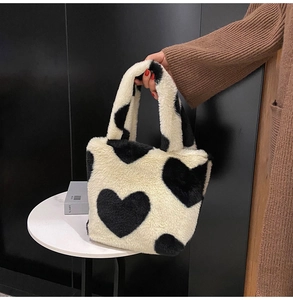 Dettaglio ravvicinato della texture in ecopelliccia con cuori sulla borsa bianca