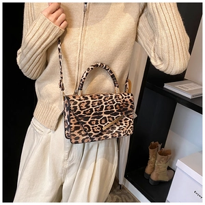 Chic leopard print crossbody bag styled with a beige knit sweater and gold hardware accents