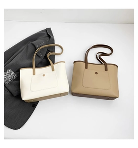 Detail view of two large tote bags in cream and khaki with contrast trim and outer pocket