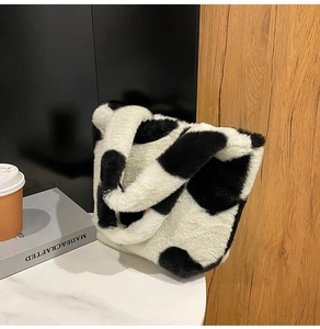 Primo piano di una borsa tote in peluche con stampa mucca e morbida ecopelliccia invernale