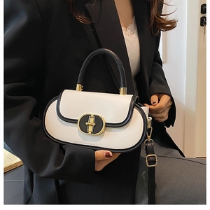 Dettaglio borsa a mano bicolore bianco e nero con chiusura dorata e tracolla