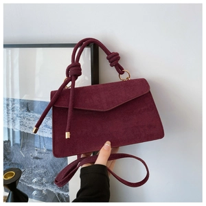 Detailaufnahme burgunderrote Handtasche aus mattem Leder mit geknotetem Griff