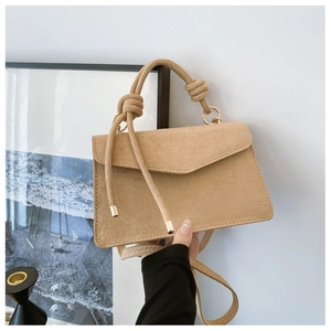Detail der camel-matten Lederhandtasche mit Seilknotengriff und V-förmigem Klappenverschluss