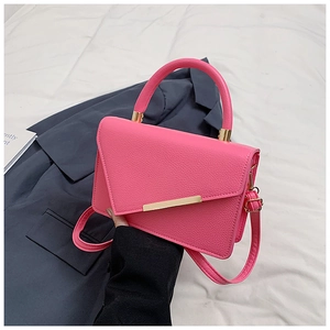 Details der rosaroten Handtasche mit Lychee-Muster und goldenen Metallteilen