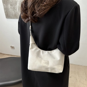 Chic cream-colored pleated underarm bag for women with fashion label and sleek strap
