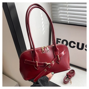 Macro shot of dark red shell bag with FASHION logo and metallic buckle details
