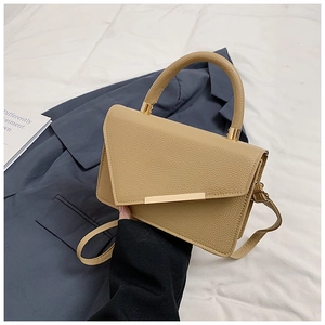 Detail der khakifarbenen Ledertasche mit asymmetrischer Klappe und goldener Schließe