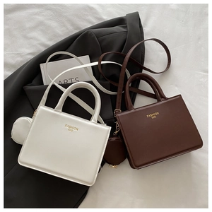 Flat lay of square leather shoulder bags in white and brown with mini coin purses