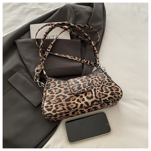 Gros plan du sac à bandoulière léopard tendance avec boucle argentée et cuir texturé