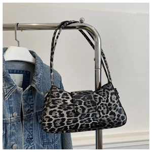 Détail d'un sac sous le bras à motif léopard avec fermeture à rabat sur un cintre