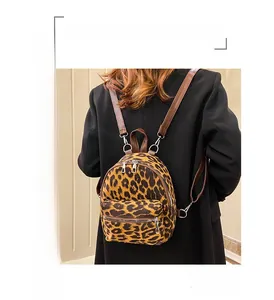 Detail of leopard print faux suede mini backpack featuring leather straps and metal zippers