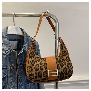 Dettaglio borsa a mezzaluna in pelliccia sintetica leopardata con finiture in pelle marrone