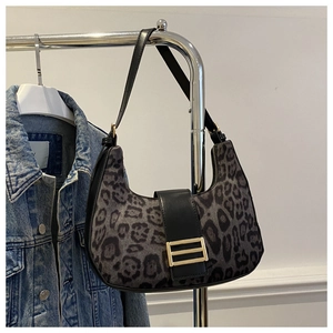 Dettaglio borsa hobo leopardata con fibbia dorata e tracolla in pelle nera su appendino