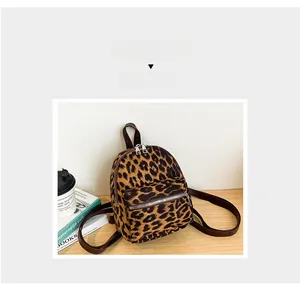 Detail view of leopard print faux suede backpack with durable brown straps and silver zippers